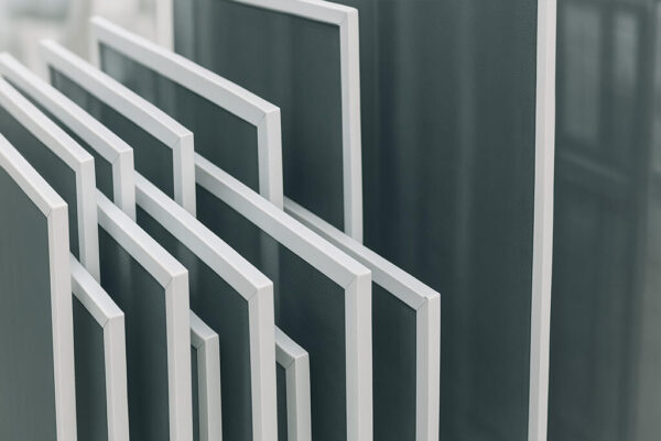 stacked replacement flyscreens of various sizes with white frames